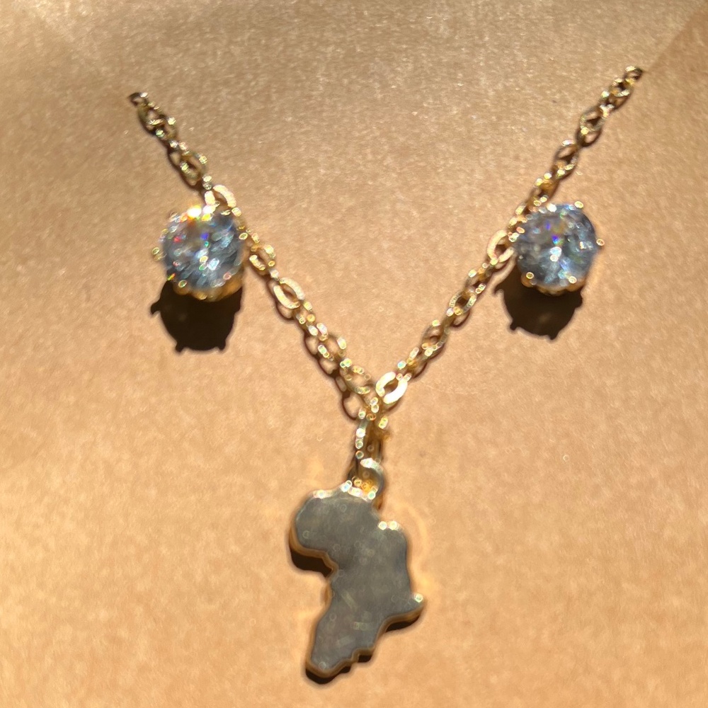 Small Africa continent charm on chain with pair of clear stone earrings